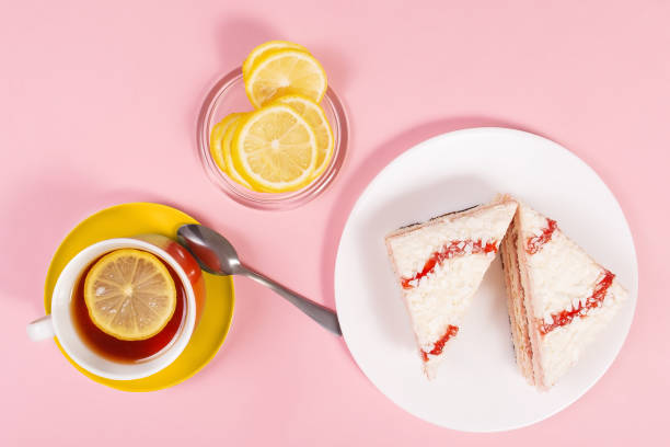 istock tea with lemon and cake on a rose background 1340942745