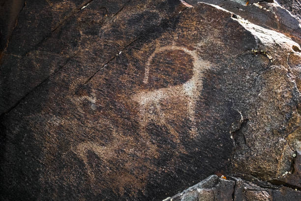 Ancient cave paintings on rocks. Bronze Age, Iron Age and Middle Age rock art. Tanbaly tas petroglyphs in Kazakhstan. UNESCO World Heritage. Tourism, travel in Kazakhstan concept.