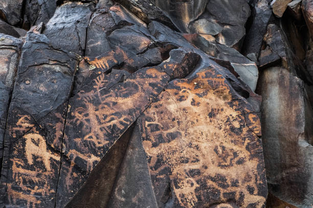 istock Ancient cave paintings on rocks. Bronze Age, Iron Age and Middle Age rock art. Tanbaly tas petroglyphs in Kazakhstan. 1340942841