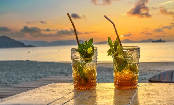 bebidas con playa borrosa y puesta de sol de fondo - ron fotografías e imágenes de stock
