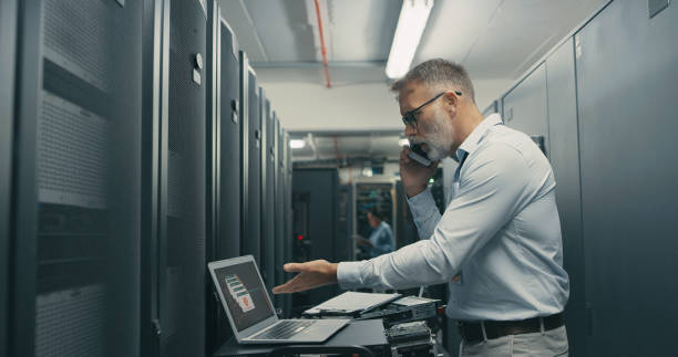 istock Shot of a mature man using a laptop and smartphone while working in a data centre 1340943107
