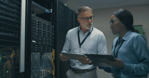 istock Shot of a man and woman using a digital tablet while working in a data centre 1340944115