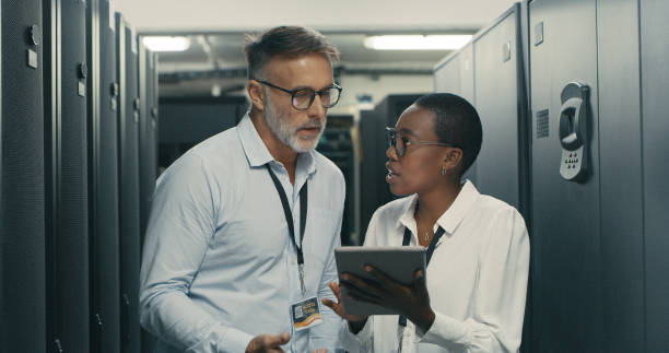 istock Shot of a man and woman using a digital tablet while working in a data centre 1340944126