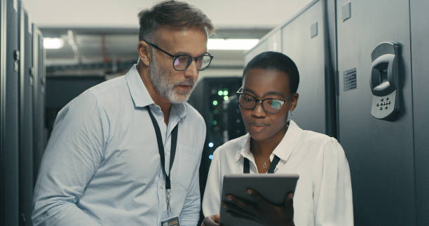 istock Shot of a man and woman using a digital tablet while working in a data centre 1340944127