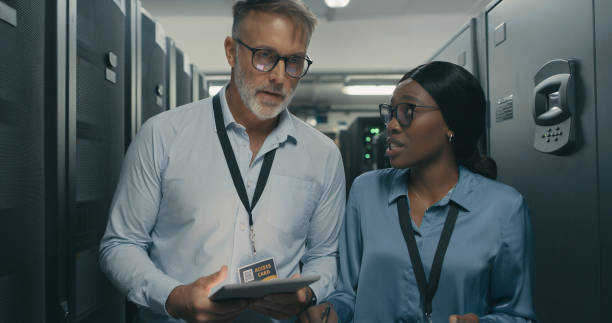 istock Shot of a man and woman using a digital tablet while working in a data centre 1340944430