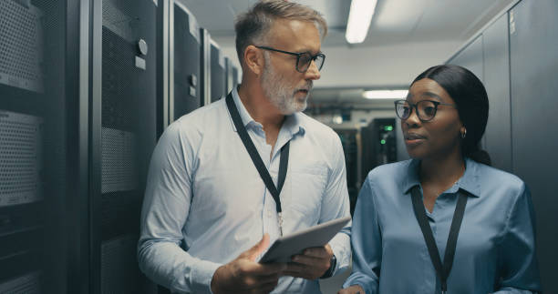 istock Shot of a man and woman using a digital tablet while working in a data centre 1340944431