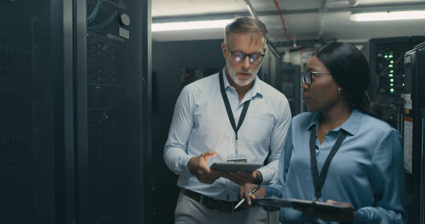 Shot of a man and woman using a digital tablet while working in a data centre