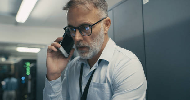 istock Shot of a mature man using a smartphone while working in a data centre 1340946353