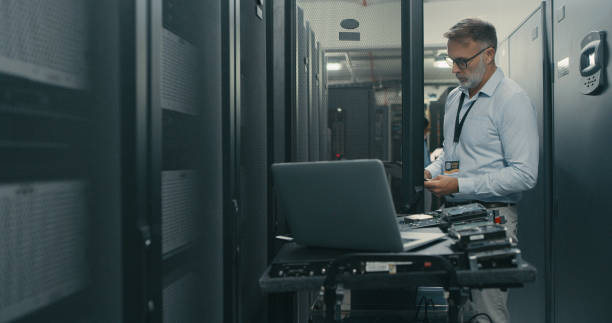 istock Shot of a mature man using a digital tablet and laptop while working in a data centre 1340946355