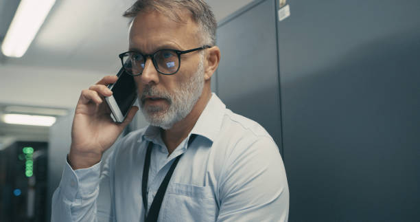 istock Shot of a mature man using a smartphone while working in a data centre 1340946357