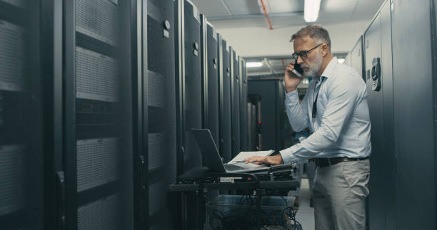 istock Shot of a mature man using a laptop and smartphone while working in a data centre 1340946362