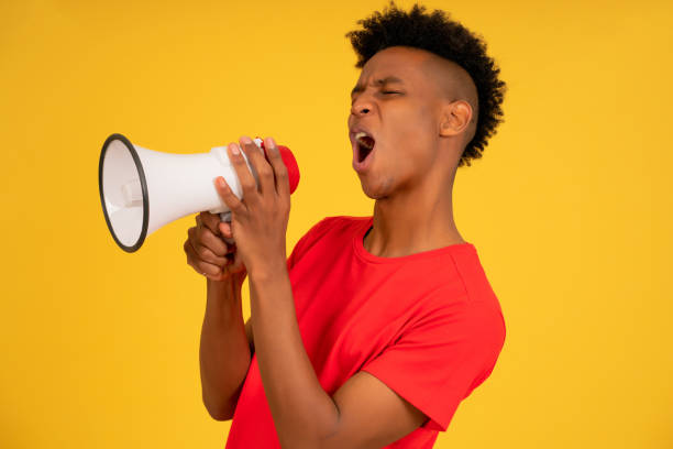 istock Afro man using a megaphone to raise his voice. 1340946398