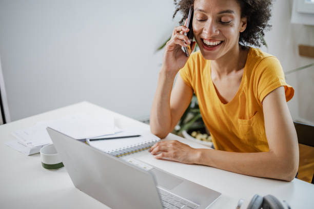 istock Woman is using laptop and talking on the phone 1340948533