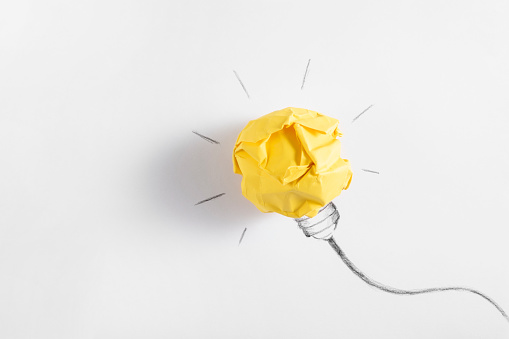 Ideas with yellow paper crumpled ball  on white paper