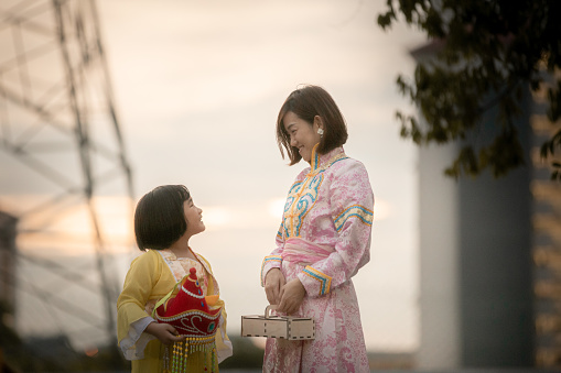 Asia Chinese mother and daughter with traditional clothes holding moon cake  box  enjoy moon cake festival