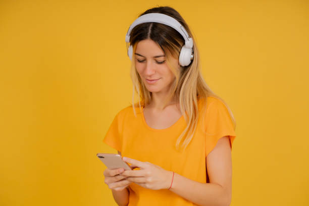istock Young woman using a mobile phone and headphones. 1340955233