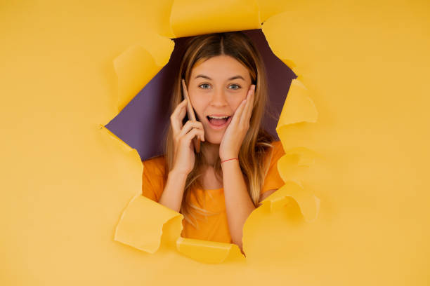 istock Young woman looking shocked while talking on the phone. 1340955234