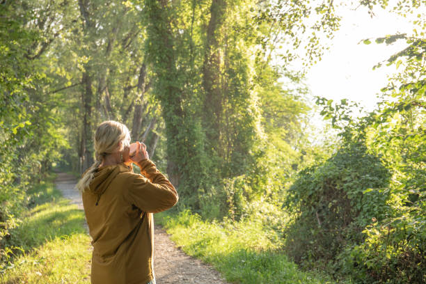 la donna si ferma sul sentiero boscoso prima dell'escursione mattutina - footpath field nature contemplation foto e immagini stock