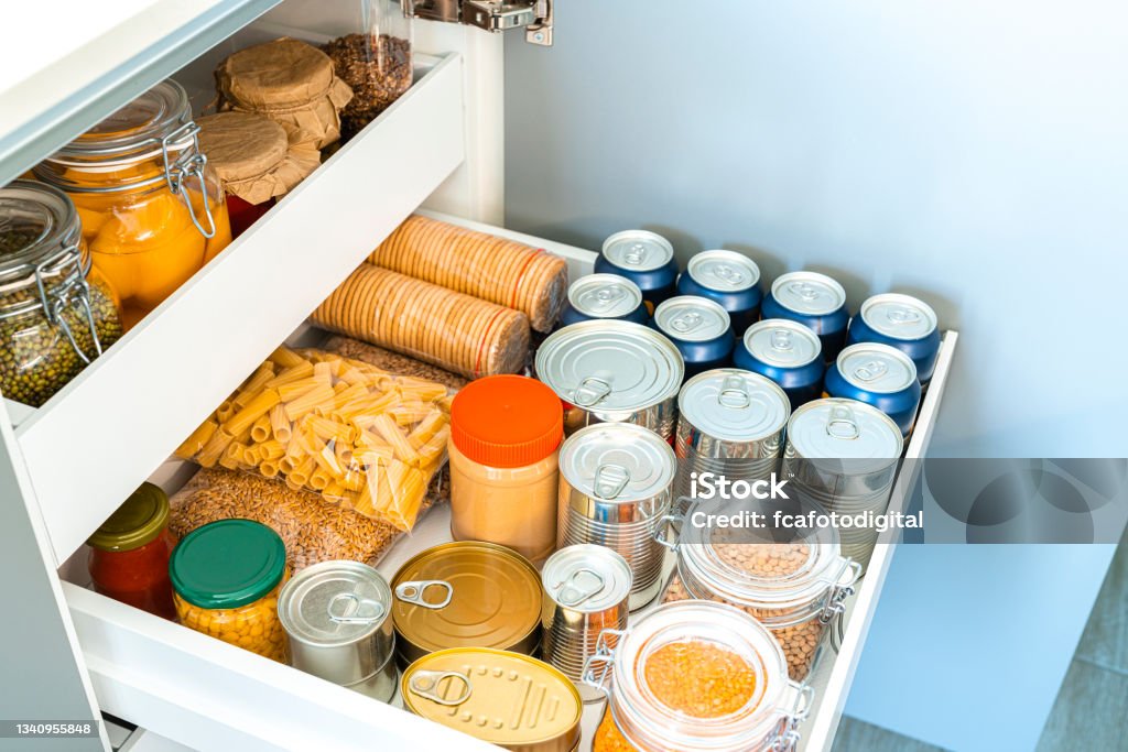 Kitchen storage drawer with canned food Close up view of an open kitchen storage drawer filled with canned food. High resolution 42Mp studio digital capture taken with SONY A7rII and Zeiss Batis 40mm F2.0 CF lens Kitchen Stock Photo