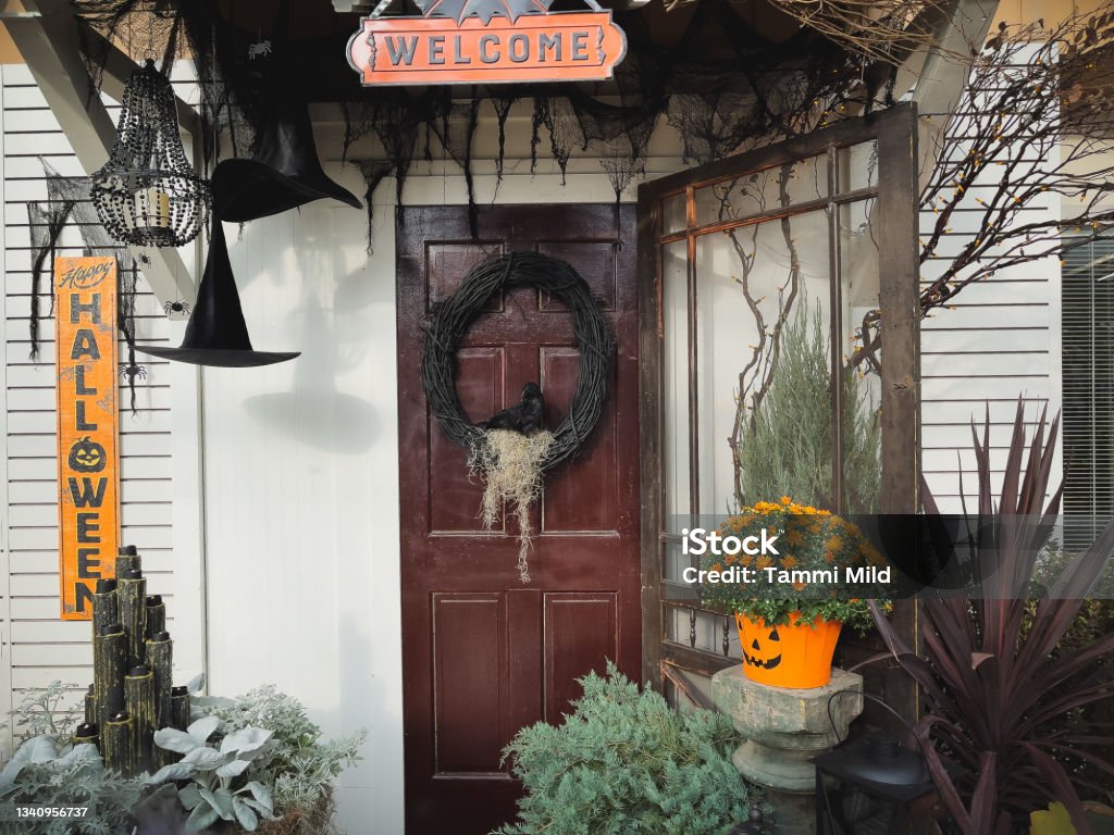 Front porch decorated for Halloween Holiday Spooky front entrance Halloween decor. Welcome sign, wreath on door Halloween Stock Photo