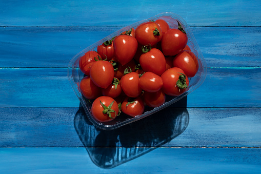 Fresh ripe tomatoes in a plastic container