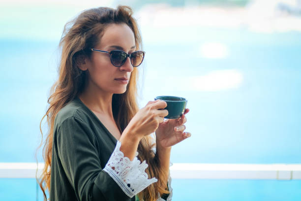 frau mit kaffee in der urlaubsruhe - wedding beach groom bride stock-fotos und bilder