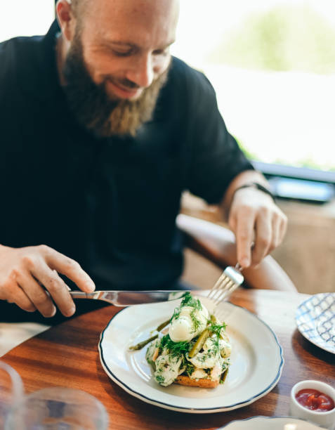 istock Man with a beard eats a casual lunchtime gourmet meal at a restaurant 1340958194