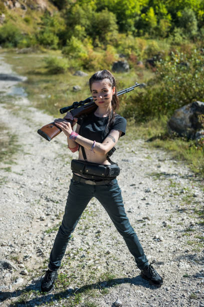 istock pretty female hunter in top in forest with weapon in nature. 1340959193