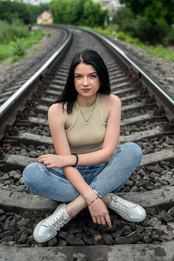 young prety lady enjoy summer time on the train track in the nature