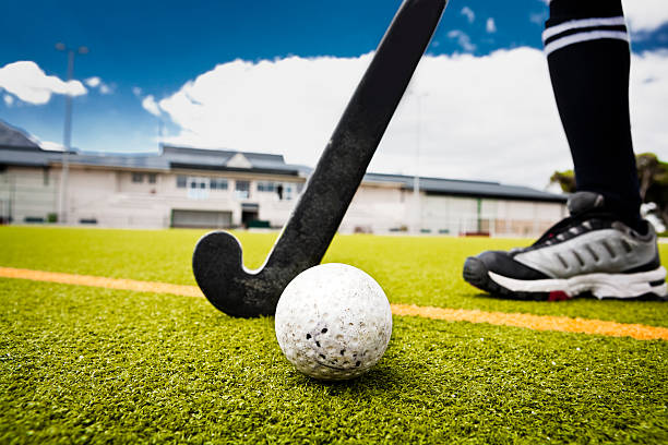Field hockey Hockey ball, hockey stick, pavilion, artificial turf. The ball is in sharp focus. Camera: Canon EOS 5D. field hockey stock pictures, royalty-free photos & images