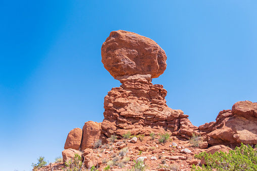 A close up low down view of Balanced Rock in Arches National Park, Utah on a sunny day.