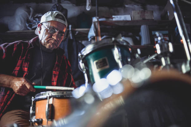 istock An older man practices playing drums in his garage 1340968059