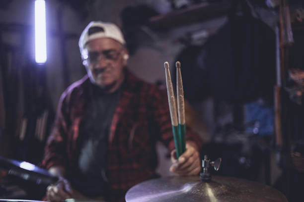 istock An older man practices playing drums in his garage 1340971997