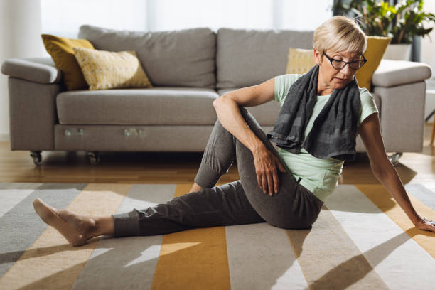 istock Mature woman doing stretching exercises at home 1340977289