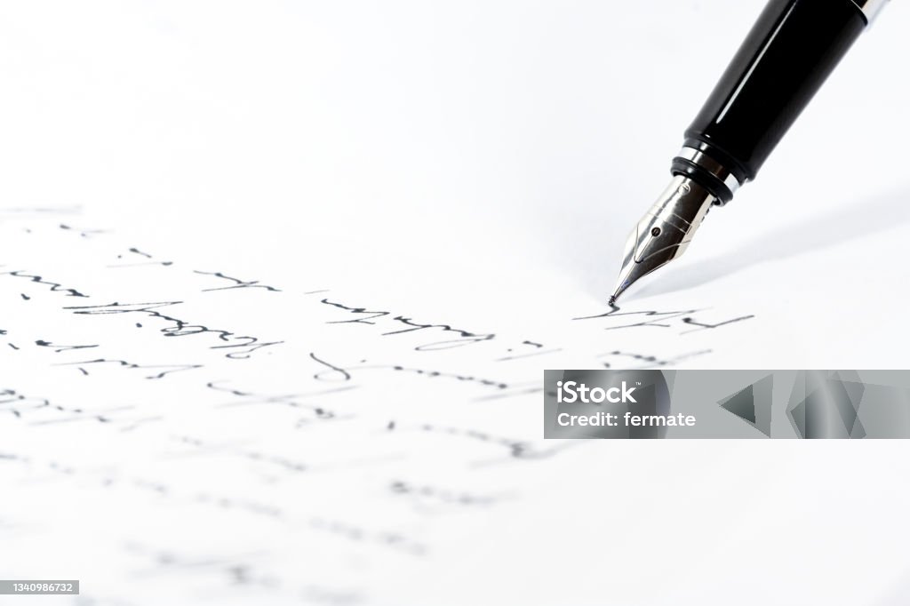 Black fountain pen is writing a letter or a manuscript on a white paper, copy space, close-up shot with selected focus Black fountain pen is writing a letter or a manuscript on a white paper, copy space, close-up shot with selected focus and narrow depth of field Writing - Activity Stock Photo
