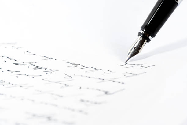 black fountain pen is writing a letter or a manuscript on a white paper, copy space, close-up shot with selected focus - literatura imagens e fotografias de stock