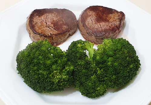 Two steaks and three pieces of broccoli