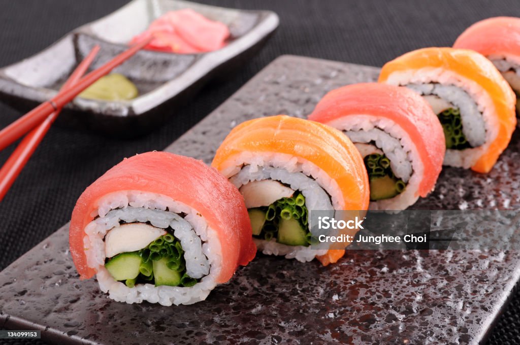 Salmon and tuna sushi roll Salmon and tuna sushi roll on a black plate. Asia Stock Photo