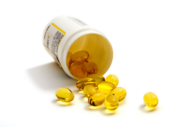 gelbe details - cod liver oil fish oil vitamin e vitamin pill stock-fotos und bilder