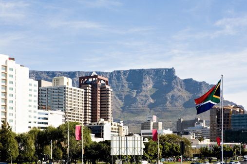 Table Mountain rises behind downtown Cape Town, South Africa. The South African flag flies at right. Camera: Canon 5D.