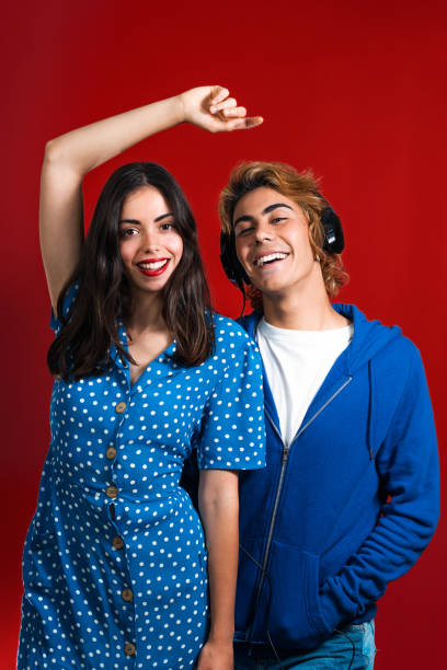 istock Vertical shot of Two caucasian models posing in front of a red wall 1340993694