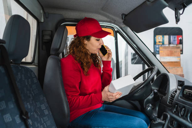 istock Female delivery driver calling a person about their package 1340995128