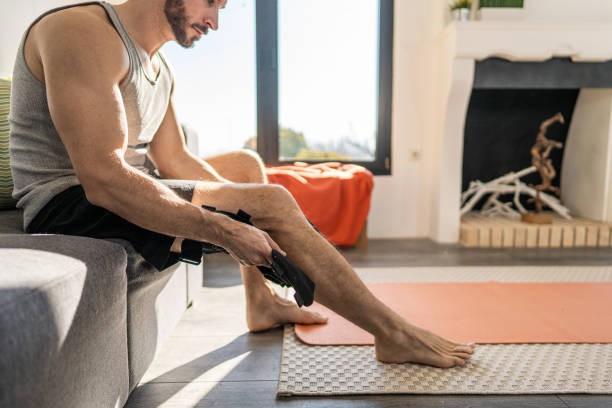 Young man putting on knee bandage fixator before exercising