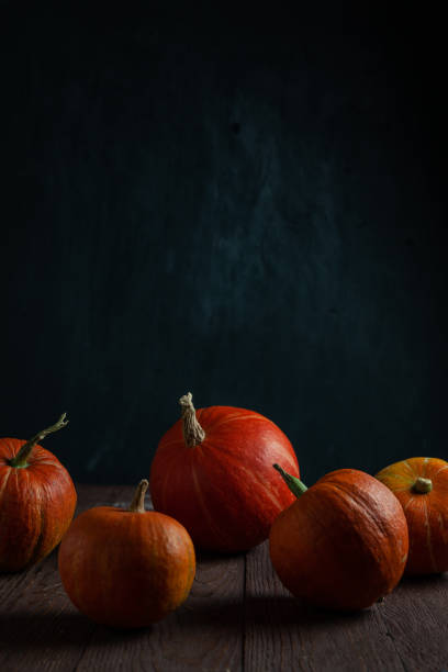istock Pumpkins in a row on wooden table. Copy space. Vertical orientation. 1341000627