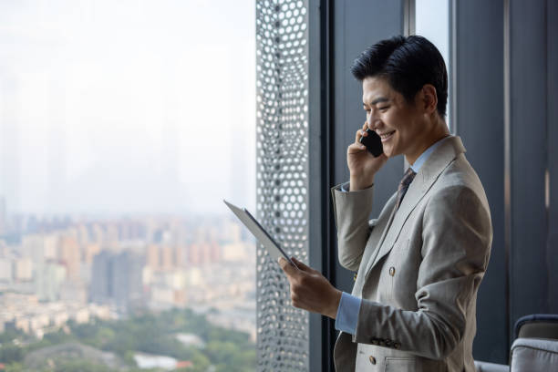 istock Asian businessmen using mobile phones 1341007327