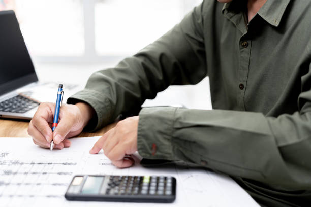 istock A man use pencil write in drawing in engineering work  with calculator paint chart and drawing on table 1341008288