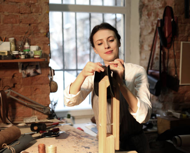 istock young woman works in a workshop, sews leather bags 1341017069