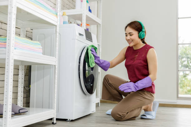 feliz ama de casa limpiando lavadora lavadora en casa y escuchando música con auriculares bluetooth wifi internet - all laundry detergent audio fotografías e imágenes de stock