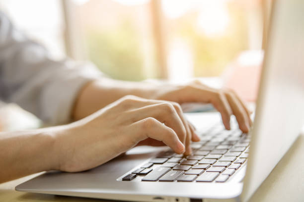 istock close up hands typing on laptop keyboard and windows light background 1341019255