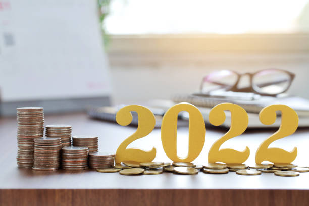 Word 2022 put on coins with coins stack on desk .Savings New year Concept.
